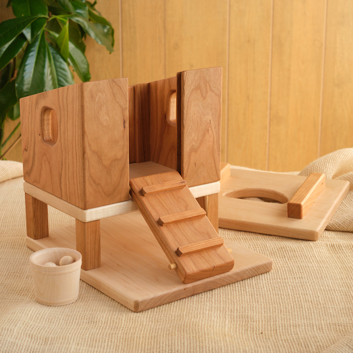 Wooden hen house with open side panels, ramp steps, and empty feeding tray