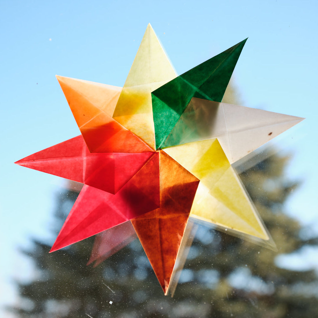 Colorful kite paper square folds arranged into a star pinwheel