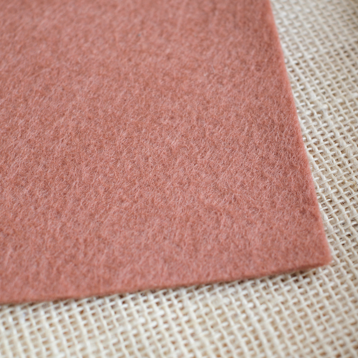 Rose wool felt sheet with soft textured surface, shown at an angle.