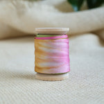 Multicolor silk ribbon spool with pink and yellow strands
