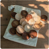 Stacking Wooden Checkers in a Muslin Bag